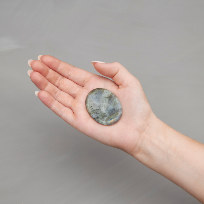 wholesale labradorite soothing stone in the palm of a woman's hand