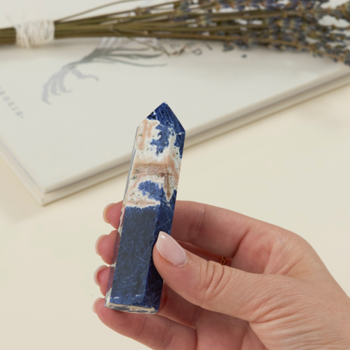 a woman's hand holding a wholesale sodalite crystal tower