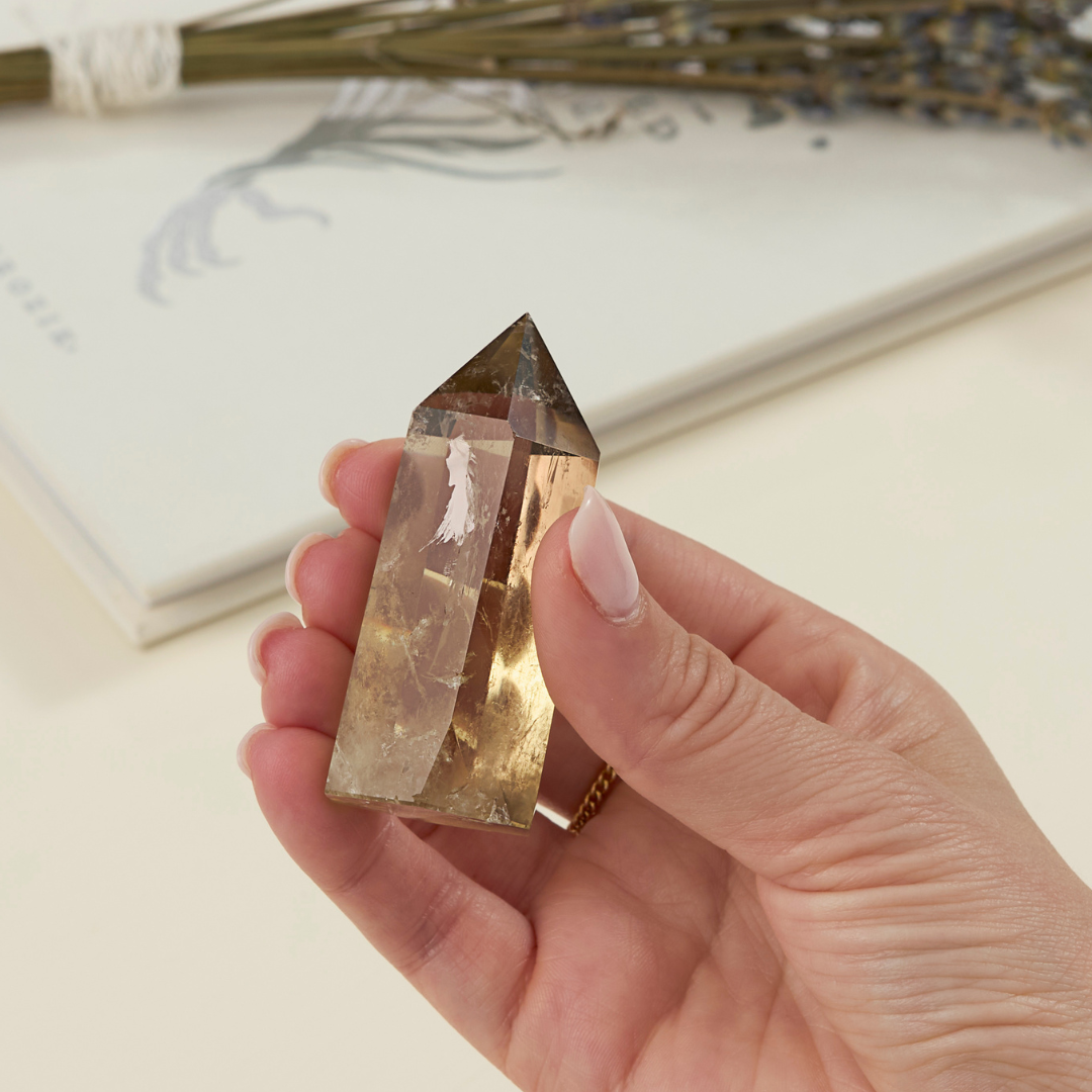 a woman's hand holding a wholesale citrine crystal tower