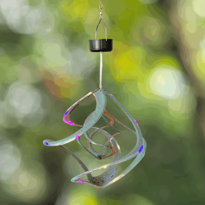 Wholesale hanging garden decor - patinaed wind spinner on blurred outdoor background