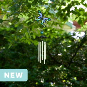 faux stained glass blue and green butterfly wind chime with silver aluminum chimes and a crystal prism weight hanging outdoors