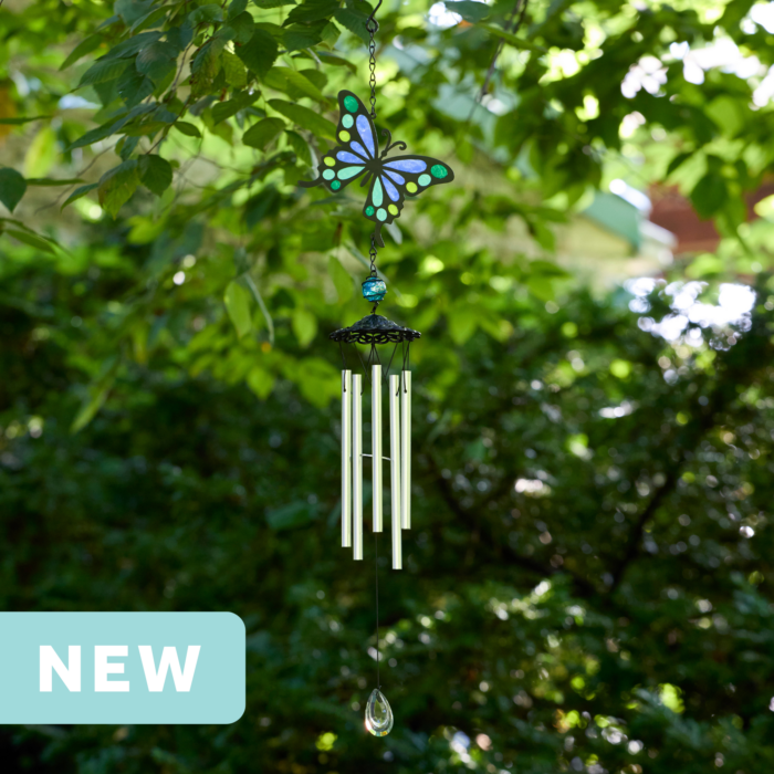 faux stained glass blue and green butterfly wind chime with silver aluminum chimes and a crystal prism weight hanging outdoors