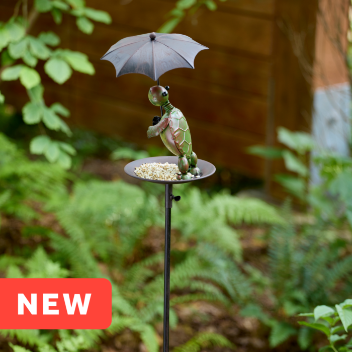 wholesale birdfeeder featuring a turtle holding an umbrella on an outdoor background with greenery