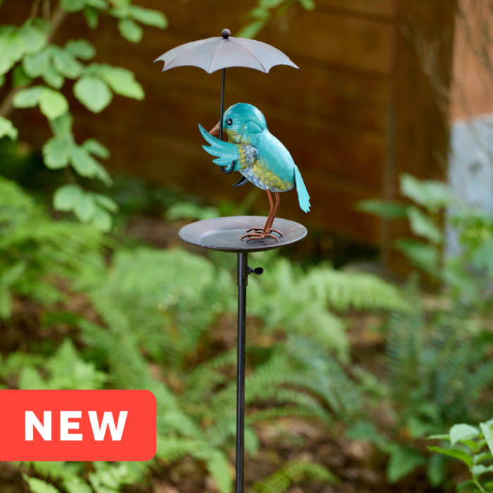 wholesale birdfeeder featuring a bluebird holding an umbrella on an outdoor background with greenery