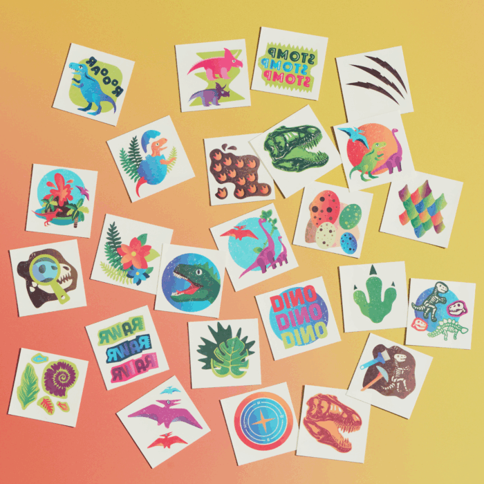 smiling child wearing wholesale dinosaur themed kids temporary tattoos - pterodactyl, t-rex, brachiosaurus, Styracosaurus, stegosaurus, fossils, volcanoes, footprints, flora and fauna