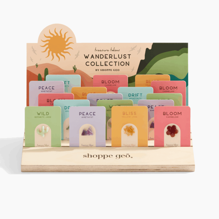 5 wholesale mini carved crystals mounted on backer cards - carnelian hibiscus, nephrite jade cactus, amazonite wave, amethyst mountain, yellow jade sun on a wooden card display with a backer card that reads Treasure Tokens Wanderlust Collection.