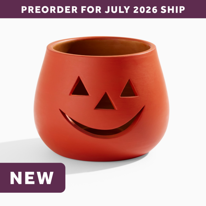 wholesale orange clay jack o lantern candle holder featuring a smiling face with triangle eyes and a triangle nose. text says: preorder for july 2026 ship. NEW.