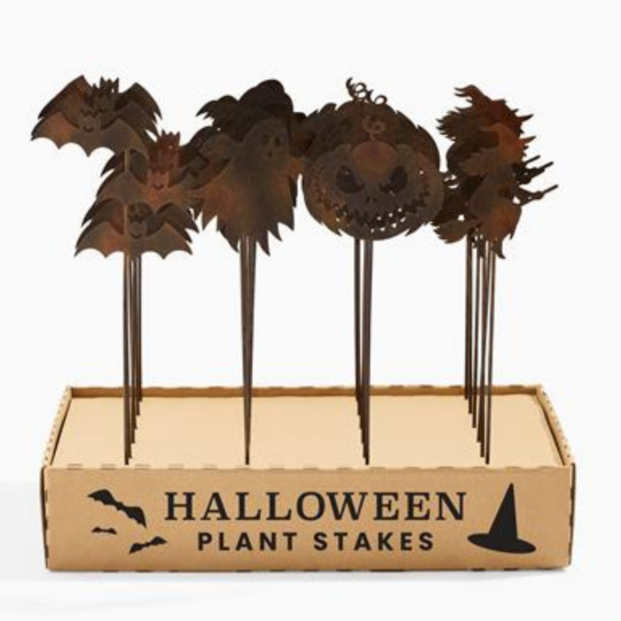 wholesale halloween garden stakes with a rusty finish. there ate four different styles of stakes in a cardboard display that says "halloween plant stakes" with bats and a witch hat.